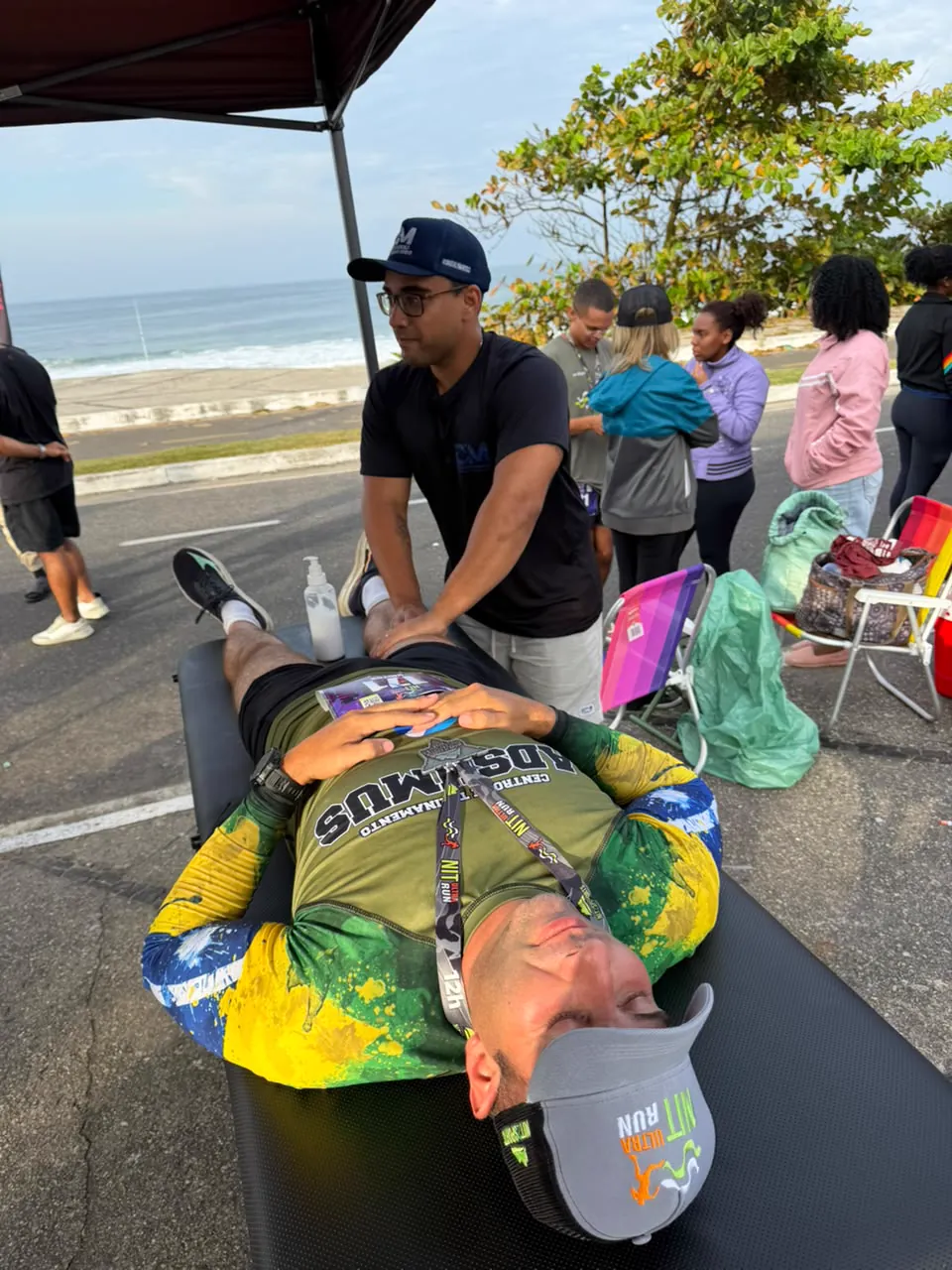 Massagem de recovery em atleta na maca, à beira-mar, durante a NIT Ultra Run