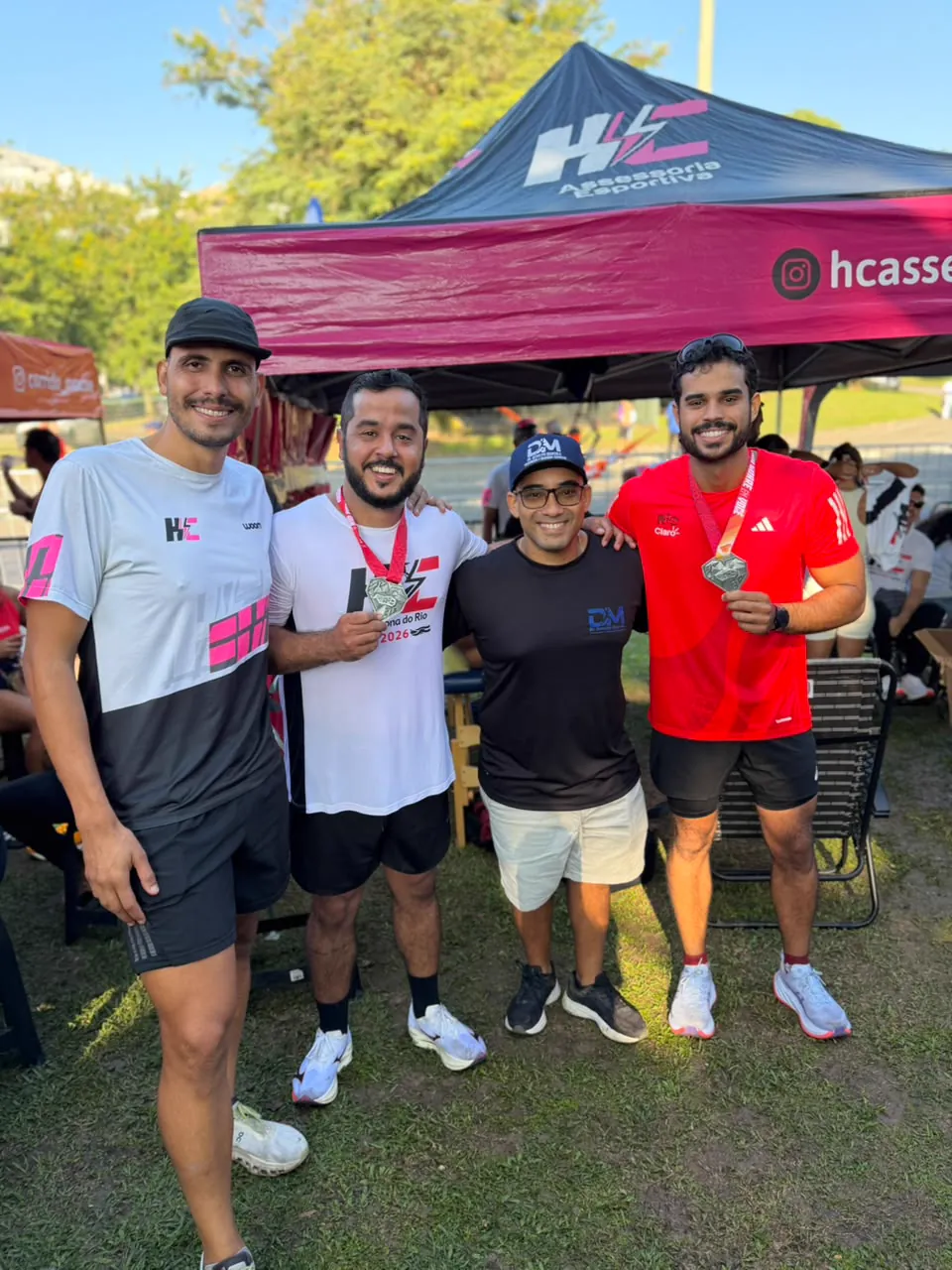 Dr. Develyn com corredores medalhistas na tenda da assessoria esportiva