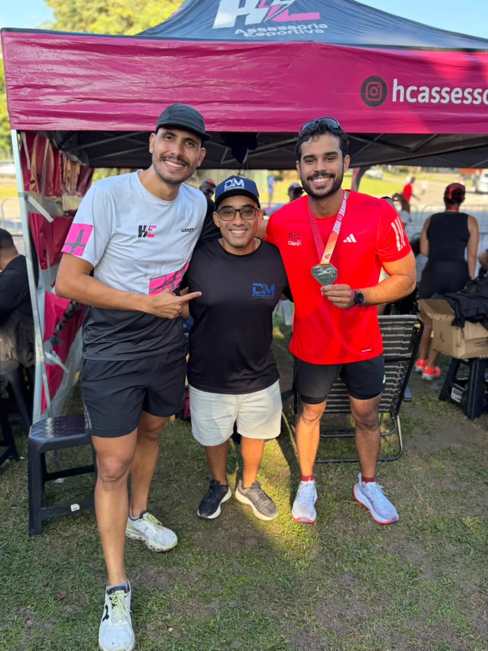 Dr. Develyn com três atletas, um deles exibindo a medalha da prova