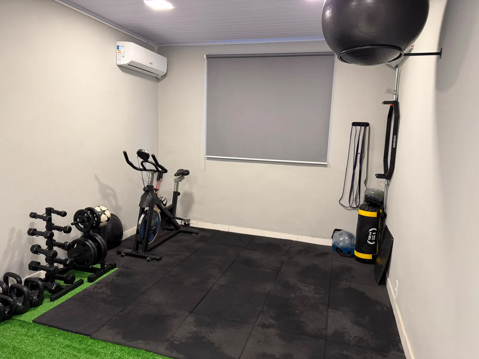 Área de treino e fortalecimento: bicicleta ergométrica, halteres, kettlebells, anilhas, bola suíça e power bag sobre piso emborrachado